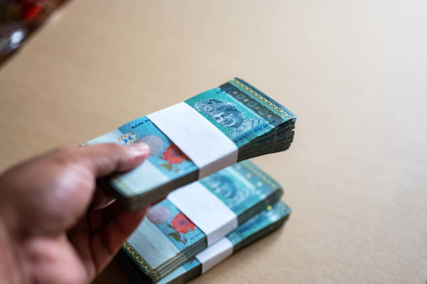 istock Male hands holding Malaysian Currency Ringgit RM50 bills stacks 1338391191
