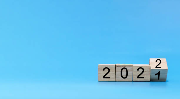 istock Happy New Year 2022 celebration. number written on wooden cube block stack on blue background, change from 2021 to 2022, new year congratulation, countdown to 2022,  goal and target plan concept 1338392393