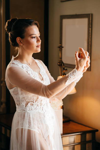 그녀의 손에 향수와 레이스 가운을 입고 아름다운 젊은 여자. 향수 - perfume wedding bride spraying 뉴스 사진 이미지