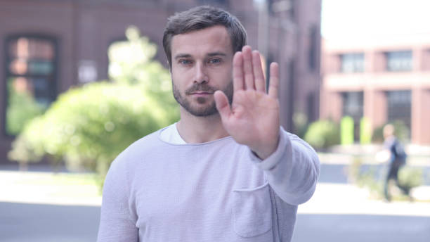 istock Not Allowed, Gesture of Stop by Handsome Man Standing Outside 1338394998