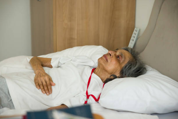 anciana frágil acostada en una cama en un hospital o hogar de ancianos, reino unido - de bajo peso fotos fotografías e imágenes de stock