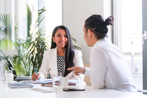 istock Two Asian Business People Collaborating at Work 1338400751