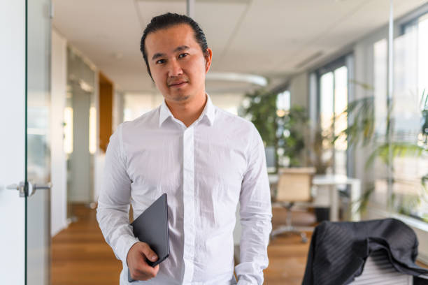 istock Aspiring Asian Young Adult Businessman Using a Digital Tablet 1338400796