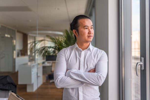 istock Asian Businessman in 30's Standing With Hands Crossed 1338400809
