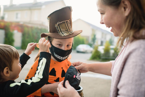istock Mother putting protective face mask on her children on Halloween 1338403080