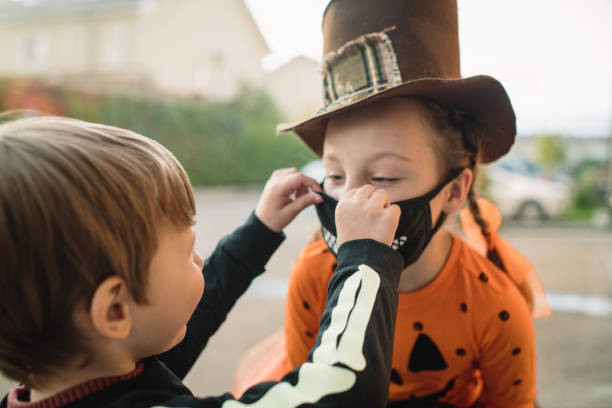 istock Mother putting protective face mask on her children on Halloween 1338403082