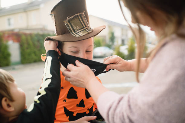 istock Mother putting protective face mask on her children on Halloween 1338404115