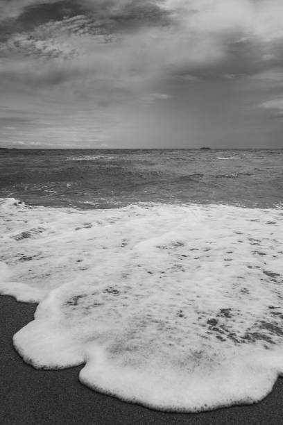 istock white sea waves with black beach 1338404187