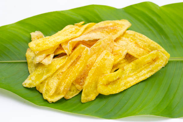 istock Banana slice chips on green leaf on white background. 1338405443