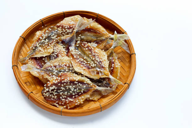istock Dried fish with sesame seeds in bamboo basket on white background. 1338406688