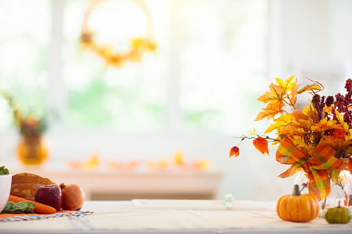Autumn or Thanksgiving decoration: overhead view of gourds, dry leaves, burning candle, pine cones shot on rustic wooden table. The composition is at the top of an horizontal frame leaving useful copy space for text and/or logo. High resolution 42Mp studio digital capture taken with SONY A7rII and Zeiss Batis 40mm F2.0 CF lens