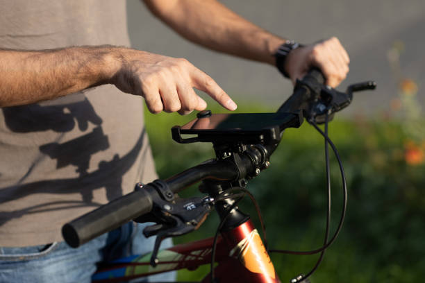 istock Man planning route using GPS navigation application in mobile phone on his bicycle bike. 1338413939