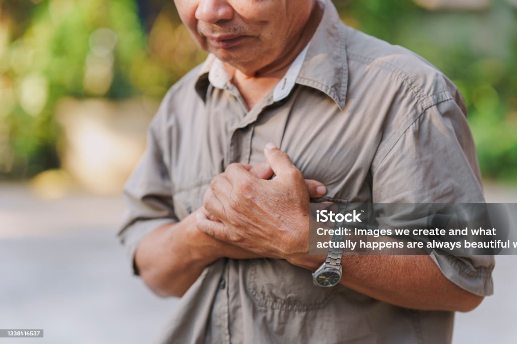 An old man holds his chest in pain. Concept of heart disease. Heart Attack Stock Photo