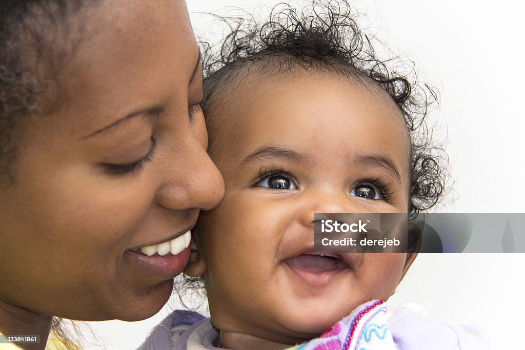 Mother and daugher A mother kissing her smiling baby girl on the cheeks Baby - Human Age Stock Photo