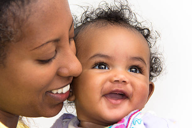 Mother and daugher A mother kissing her smiling baby girl on the cheeks ethiopian ethnicity photos stock pictures, royalty-free photos & images