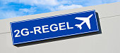 corona-2g-regel-auf-blauem-schild-und-fl
