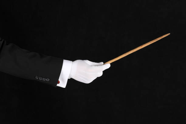 istock hand with conductor baton on black background 1338427432