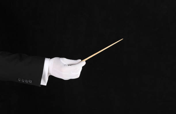 istock hand with conductor baton on black background 1338427611