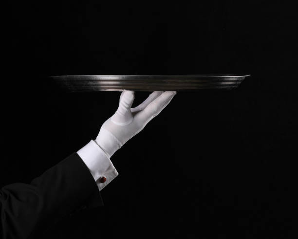 istock hand of a waiter with a tray on a black background 1338427616