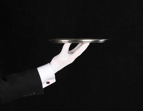 istock hand of a waiter with a tray on a black background 1338428164