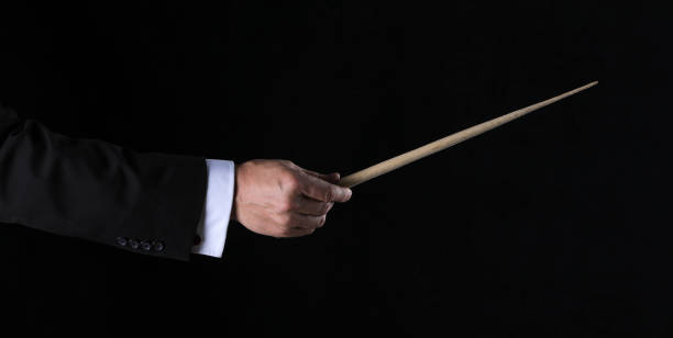 istock hand with conductor baton on black background 1338430917