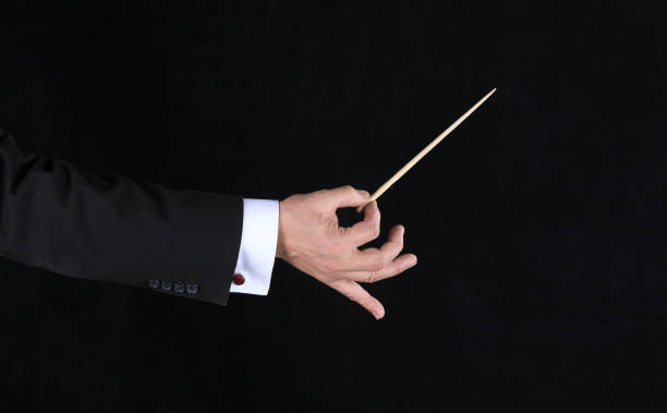 istock hand with conductor baton on black background 1338431210