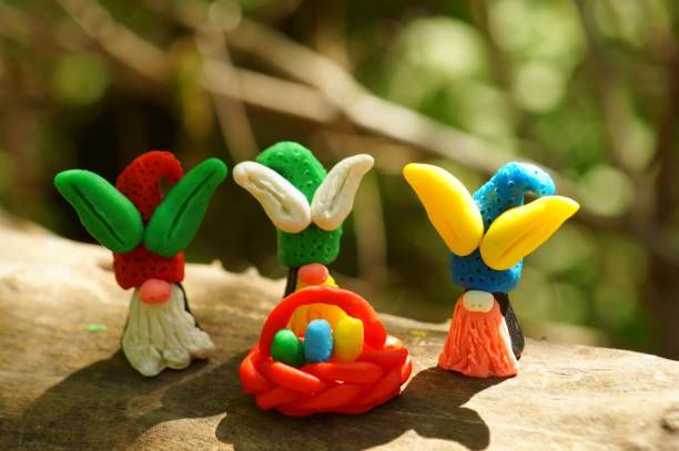 istock Figures of Easter gnomes with ears made of plasticine on a colored background. 1338434557