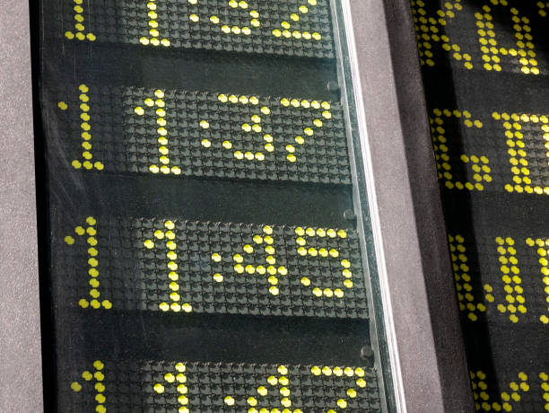 Simple train or bus station time table, different arrival and departure hours mechanical dot display detail, closeup, past 11:00, quarter to twelve, 11:45 Commute, rush, haste abstract concept, nobody