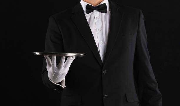 istock hand of a waiter with a tray on a black background 1338439279