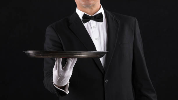 istock hand of a waiter with a tray on a black background 1338439324