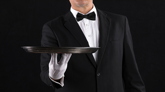 hand of a waiter with a tray on a black background