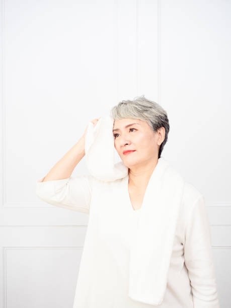 istock Active mature female refreshing and wipe sweat during workout. 1338440836