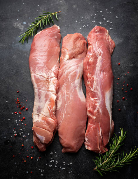 istock Fresh Raw pork tenderloin on dark background 1338441144