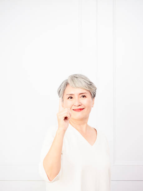 istock Senior asian woman pointing up 1 finger. 1338444563