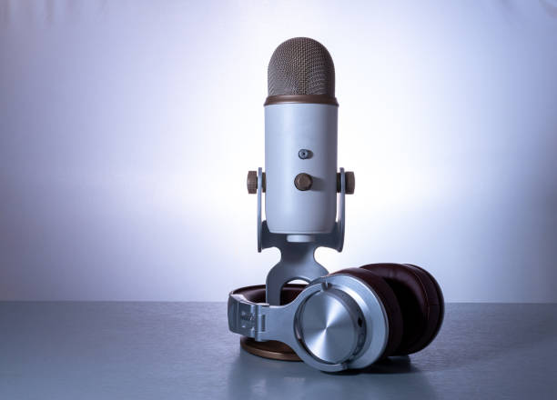 istock microphone and headphones for webcast or podcast  on light blue  background. 1338447400