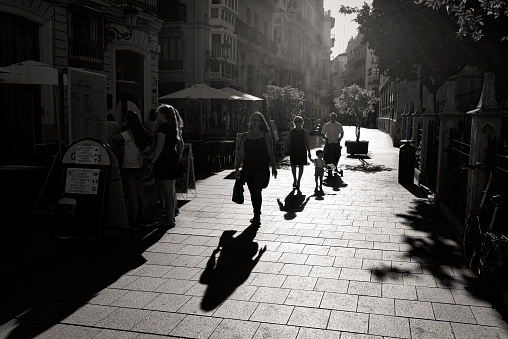 valencia spain july - 16 - 2016 unknown people walk in the city of alencia in bright sunlight and with harsh shadows