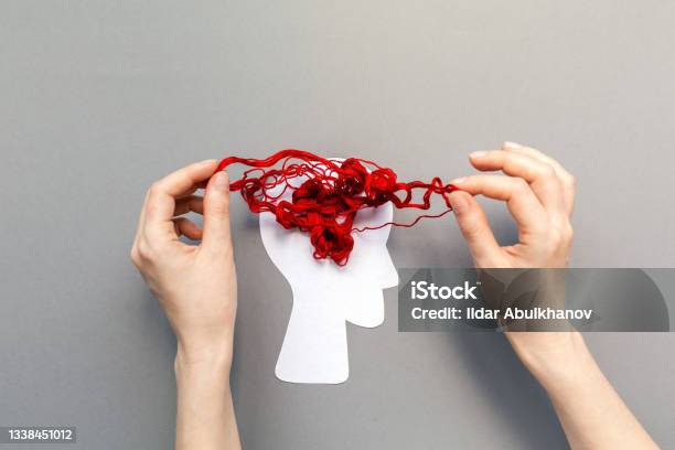 Females Hands Unravel The Tangled Red Threads On The Silhouette Of The Head Representing The Brain Gray Background Flat Lay The Concept Of Mental Health And Psyhology Problem Stock Photo - Download Image Now