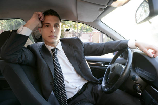 istock Young suit businessman inside his car 1338453722