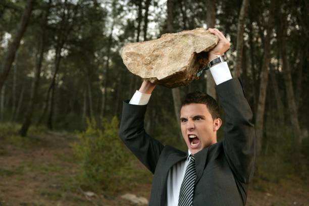 uomo d'affari arrabbiato all'aperto, grande pietra in mano - throwing people stone tossing foto e immagini stock