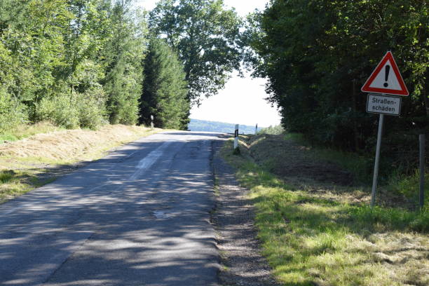 istock country road with bad road warning sign 1338456210