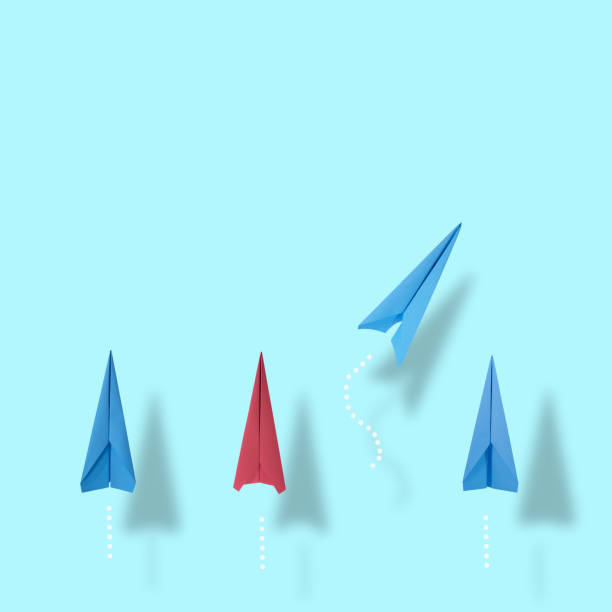 istock Business ideas for creativity and innovative solutions. A group of blue and red paper planes in one direction and one blue paper plane pointing in different directions.copy space 1338459836