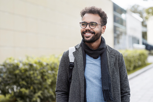 Smiling mixed race man portrait in a city. People, male beauty, city life, autumn, winter, lifestyle concept