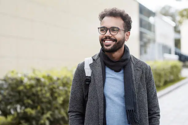 Photo of Handsome young man wearing warm clothing looking up