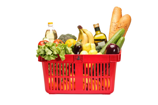A studio shot of a shopping basket full with groceries isolated on white background