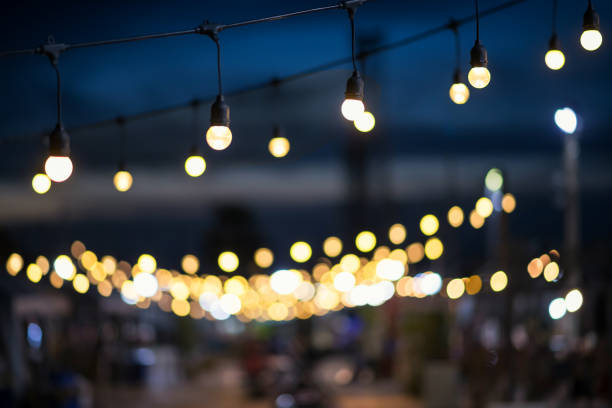 istock Hanging light bulbs with blur outdoor shopping mall 1338463701