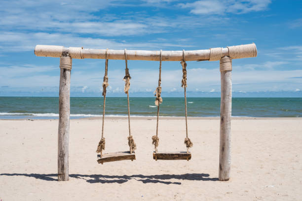 istock Wooden rope swing on white beach in summer 1338463706