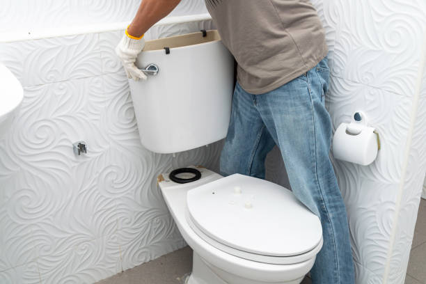 Man worker repairing with toilet tank