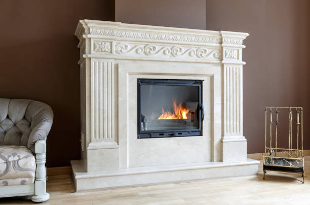istock White marble fireplace in classic style with burning wood inside. 1338469970