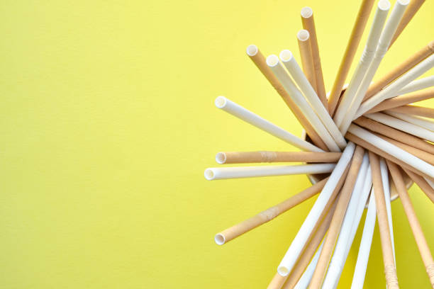 istock brown and white cardboard straws spirally placed inside a cardboard glass on the right side of the image on a yellow background 1338470446
