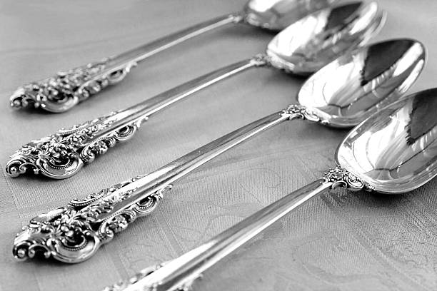Four clean silver spoons laying on table Traditional Silver Spoons  baby spoon stock pictures, royalty-free photos & images